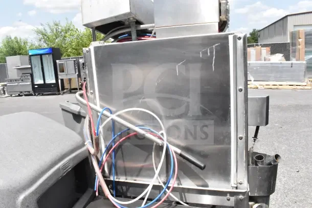 CMA AH-2 commercial pass-through dishwasher, stainless steel, visible wiring, exterior scratches, shown outdoors.