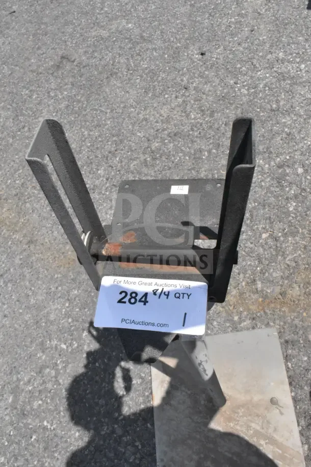 Metal stand with adjustable brackets, minor rust spots, and a sturdy base. Auction tag reads "284 8/4 QTY, PClAuctions.com."