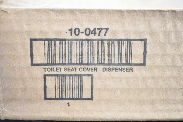 Cardboard packaging for toilet seat cover dispenser, model 10-0477, showing barcode and markings.