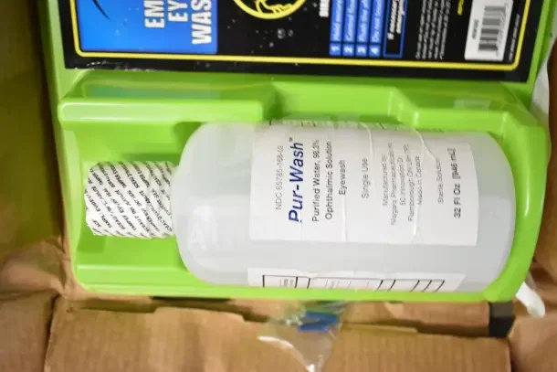 Emergency Eye & Face Wash Station with Pur-Wash bottle, 32 oz, ophthalmic solution, sealed, in mounted green tray.