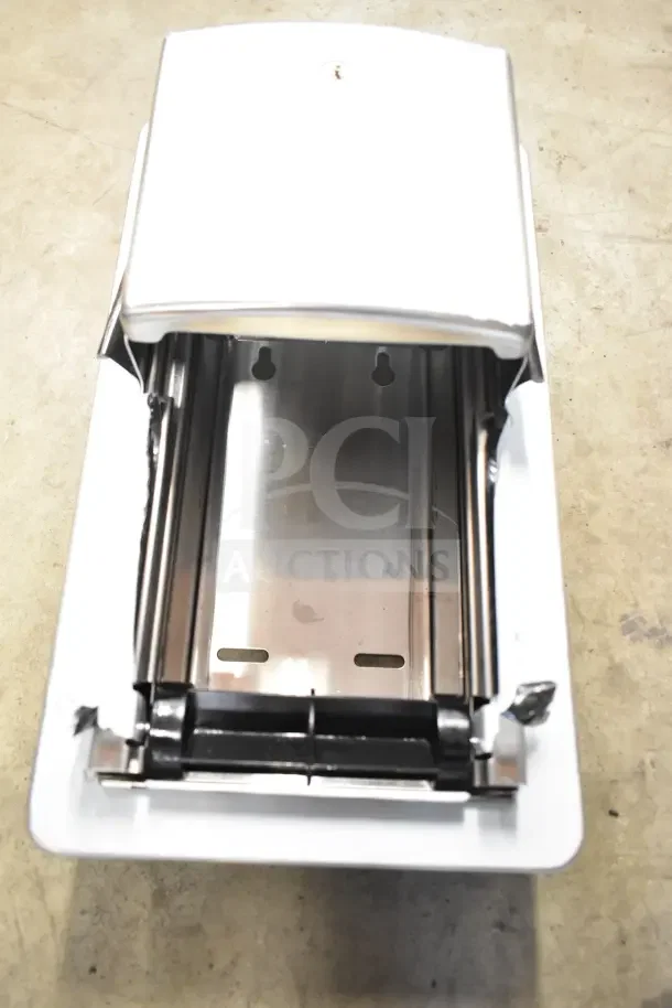 Stainless steel toilet paper dispenser, wall-mount design, with locking mechanism and dispenser slots, in good condition.
