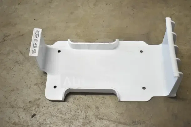 White plastic mounting bracket with release lever, labeled "PUSH HERE TO RELEASE," four screw holes, new condition.