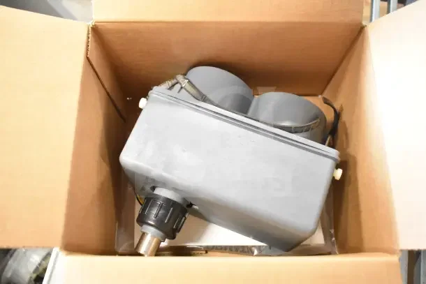 Box containing brand new items: soap dispenser, rack, and IBD bin kit, ready for auction.