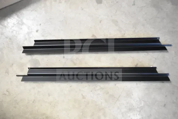 Two black adjustable shelving brackets on a concrete floor, in good condition.