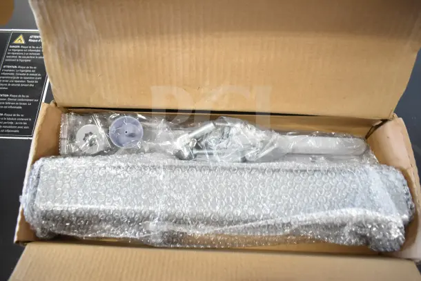 Boxed Falcon SC81A door closer, brand new, in bubble wrap with installation hardware.