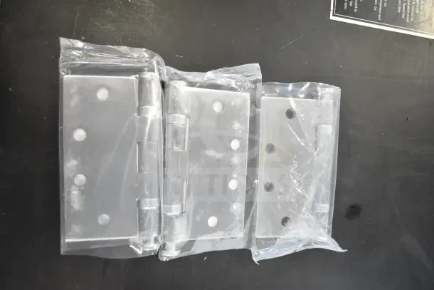 Four brand new hinges in clear packaging, showcasing durable metal construction, pristine condition.