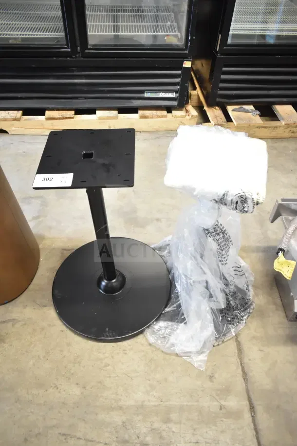 Two metal stands with round black bases; one with protective plastic wrap. Auction label reads "302, x2". Suitable for displays.