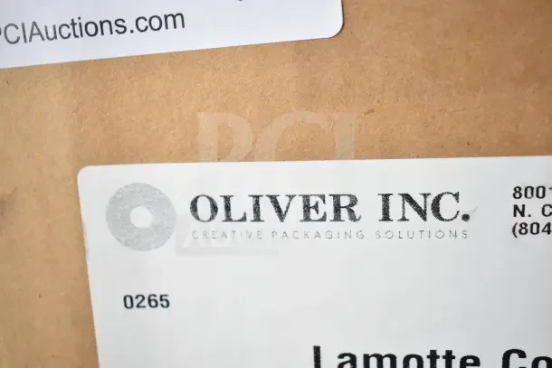 Close-up of Oliver Inc. label on scratch and dent tuck top box. Brand new condition. Packaging details visible.