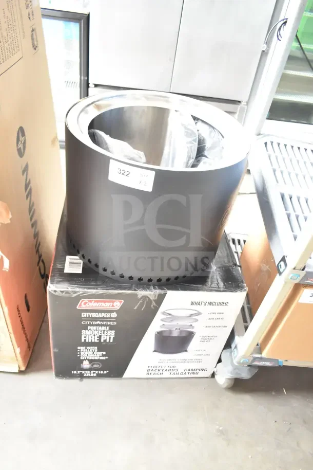 Brand new Coleman Smokeless Fire Pit, with box. Includes fire ring, ash grate, and ash catch pan. Minor dents visible.