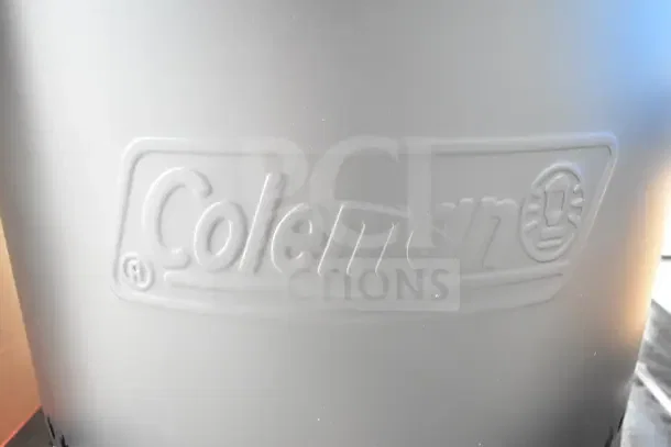 Alt text: Close-up of Coleman branding on a smokeless fire pit, indicating a new scratch and dent condition.