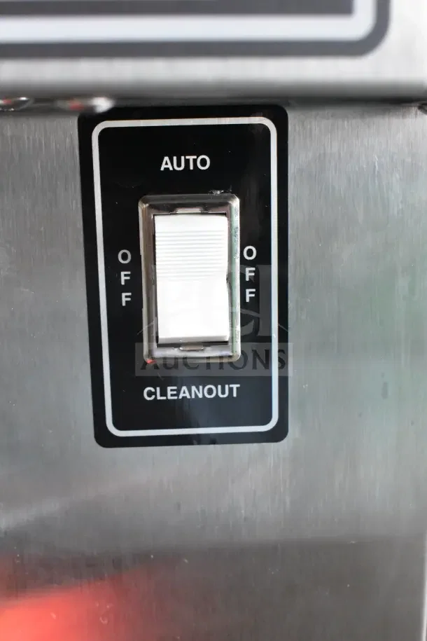 Close-up of a control switch on a SaniServ 414 air-cooled soft serve machine, labeled "Auto," "Off," and "Cleanout."