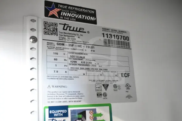 "True GDM-35F-HC commercial freezer; model label showing specs: 115V, 1-phase, refrigerant R290; scratch and dent condition."