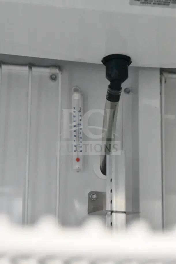 Inside view of 2025 True GDM-35F-HC freezer showing temperature gauge and metal shelving fixtures. Brand new condition.