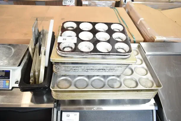 Stack of 40 assorted baking pans, including muffin trays, in various conditions. Visible tag indicates quantity.