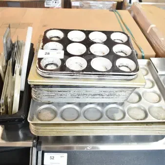 Stack of 40 assorted baking pans, including muffin trays, in various conditions. Visible tag indicates quantity.