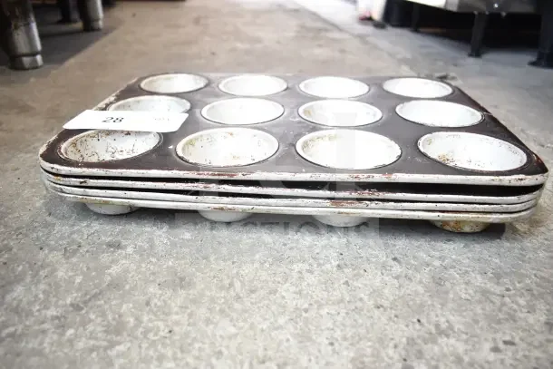 Stack of muffin baking pans in used condition, slight rust visible. Includes 40 various items total in auction lot. Item tag: 28.