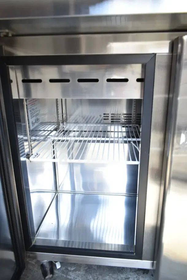 Norlake SMP36-15 prep table interior with wire shelf, stainless steel finish, and label inside. Commercial casters visible.