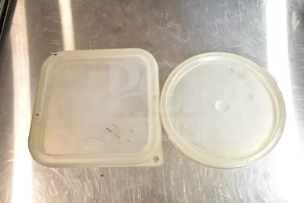 Auction item image showing two used plastic container lids, round and square, on a metal surface. Visible brand markings.