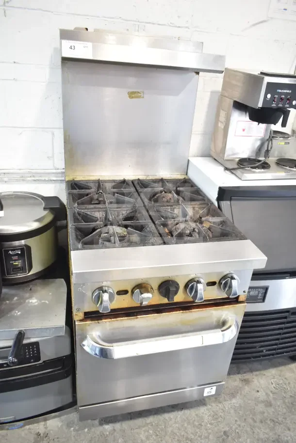 Commercial gas-powered 4 burner range with oven, over shelf, and backsplash. Sturdy, used condition with visible wear.