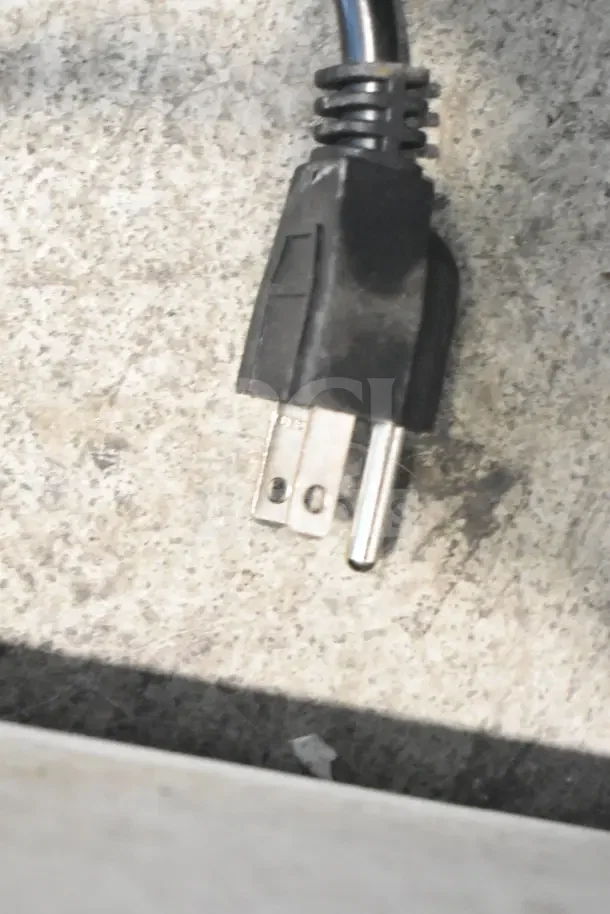 A black power plug on a textured surface, part of the Avantco 194UCF280A ice machine.