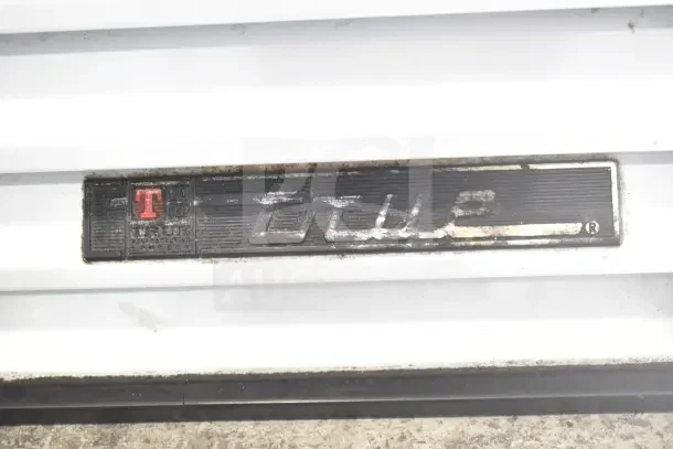 True GDM-23 Cooler nameplate showing brand and model. Slight wear visible, indicating moderate use.