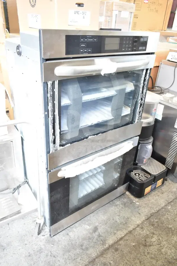 Stainless steel double stack wall mount convection oven, electric powered. Visible glass damage on doors.