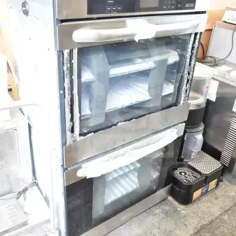 Stainless steel double stack wall mount convection oven, electric powered. Visible glass damage on doors.