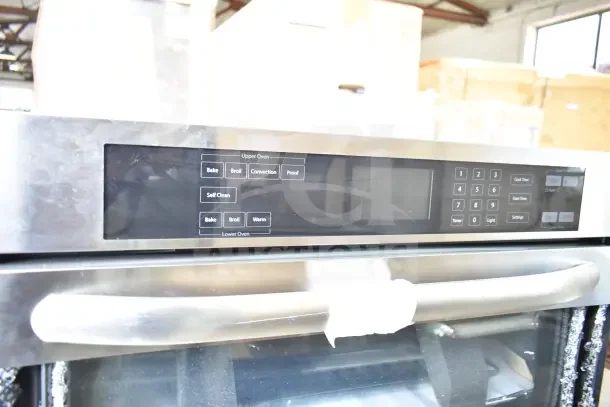 Stainless steel double stack wall mount electric convection oven, visible glass damage, control panel with bake and broil options.