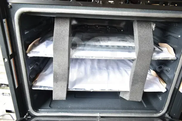 Stainless steel double stack wall mount electric convection oven; visible glass damage; includes protective packaging.