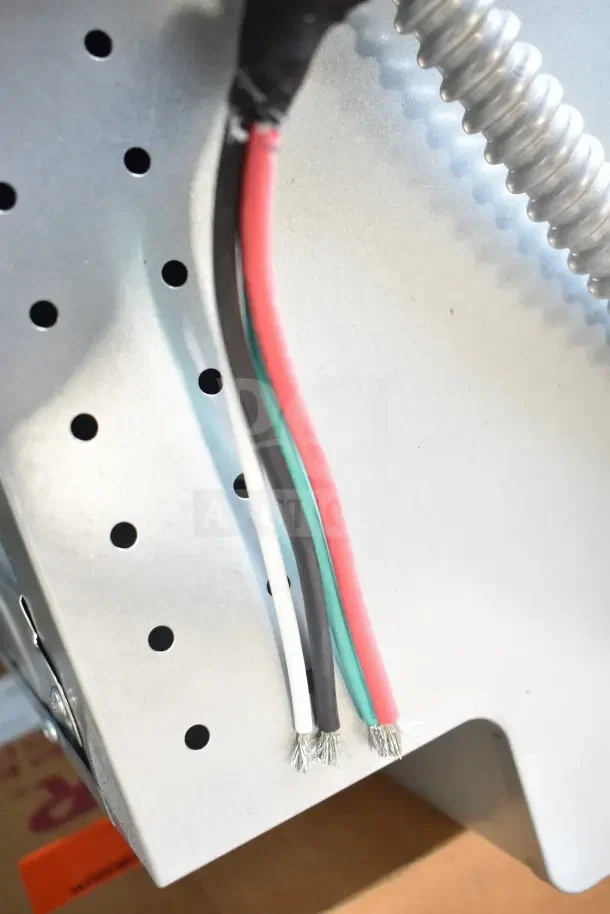 Back view of a stainless steel convection oven showing multi-colored electrical wires and metal venting on the mount.