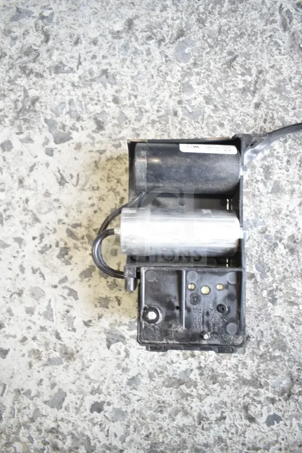 Scratch and dent item showing a motor component with visible wiring, set against a textured surface.