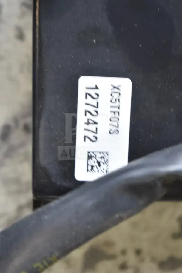 Label on a black item showing code "XC5TF07S" and number "1272472" with a QR code. Part of auction lot.