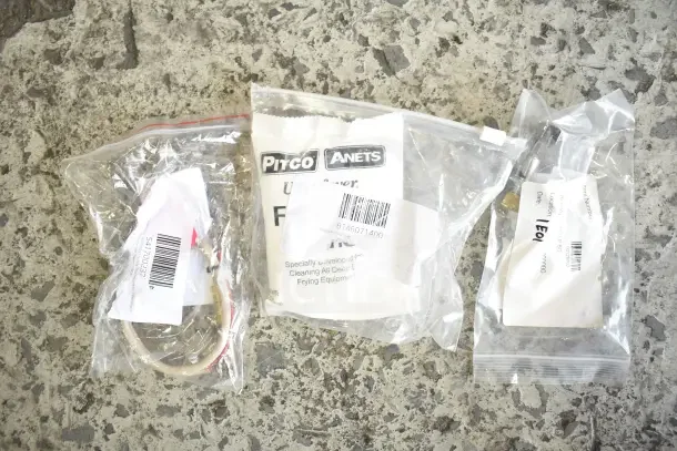28 new scratch and dent items, including gaskets, harnesses, brackets, and knobs, sealed in labeled bags.