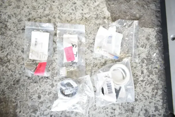 Auction lot of 28 brand new scratch and dent items, including gaskets, harnesses, and more, in labeled plastic bags.
