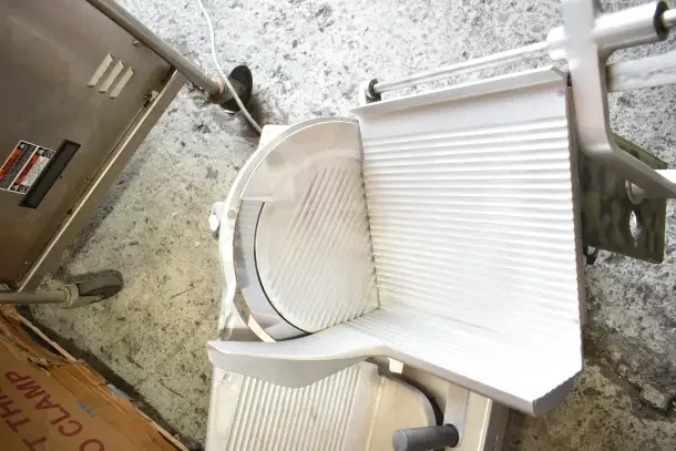 Bizerba commercial countertop meat slicer in used condition, showcasing blade and slicing platform. 120 volts, 1 phase.