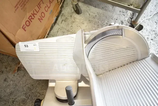 Bizerba commercial countertop meat slicer, 120 volts, 1 phase. Features a ribbed slicing tray, in used condition. Auction tag indicates lot 53.