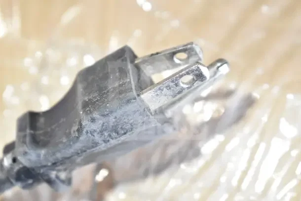 Close-up view of the power plug from a Bunn MHG commercial coffee grinder. 120 volts, worn condition.