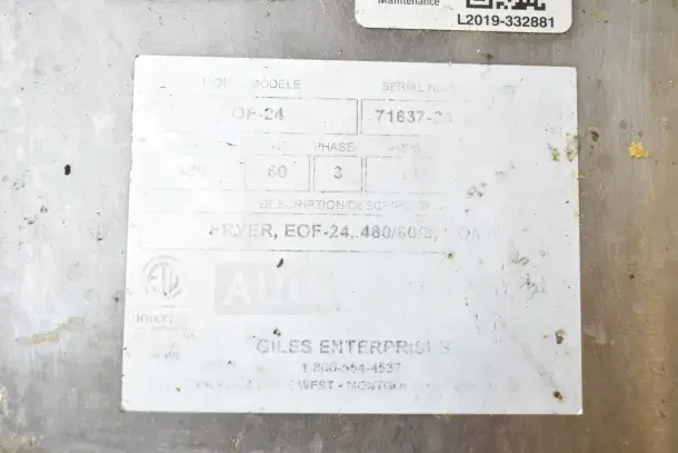 Giles EOF-24 commercial fryer label showing model, 480 volts, 3 phase, and contact info. Some wear is visible.