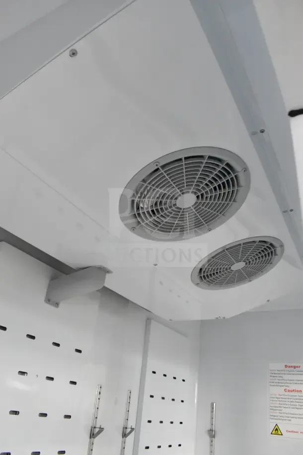Interior view of Migali C-72FM-HC freezer merchandiser showing fans and shelving. Brand new, scratch and dent condition.