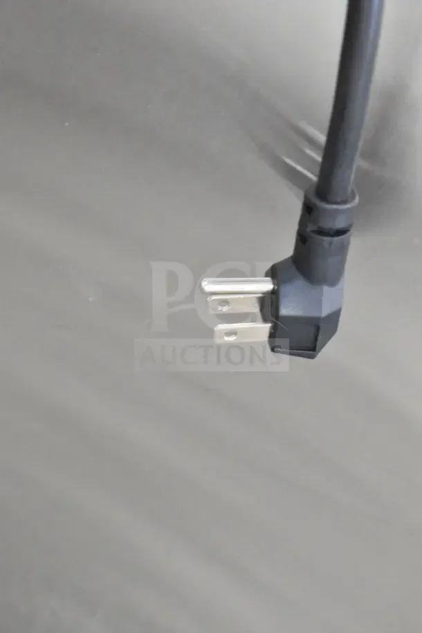 Black power plug of the Migali C-2F-HC commercial freezer against a metal background. 115 Volts, 1 Phase.