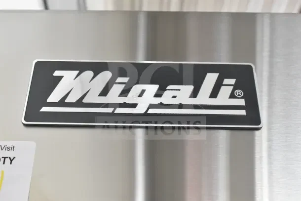 Migali C-2F-HC logo on stainless steel surface of new commercial 2-door freezer, model details visible.